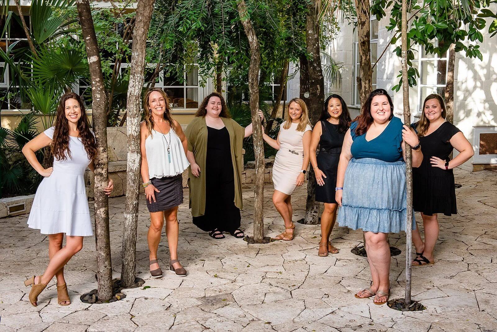 Group of women posing together outdoors with smiles.