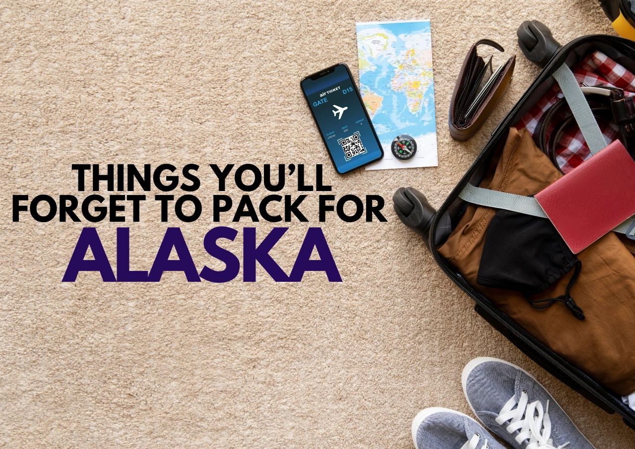 Travel essentials and a packing list for alaska displayed on a carpeted floor.
