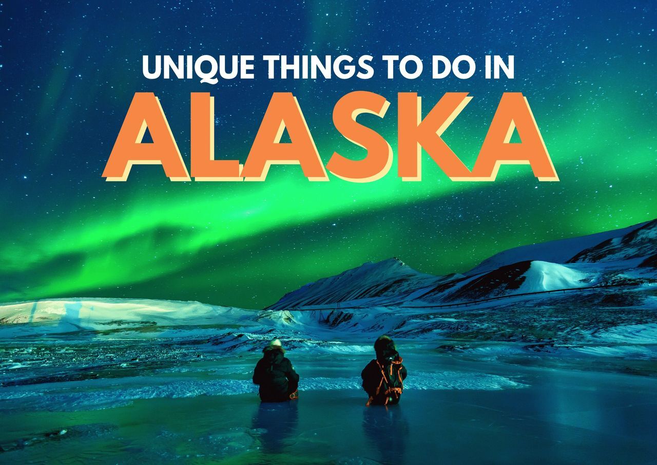 Two people sitting on an icy ground watching the northern lights in alaska.