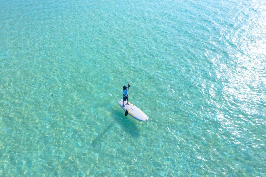 A man boating across pristine clear water
