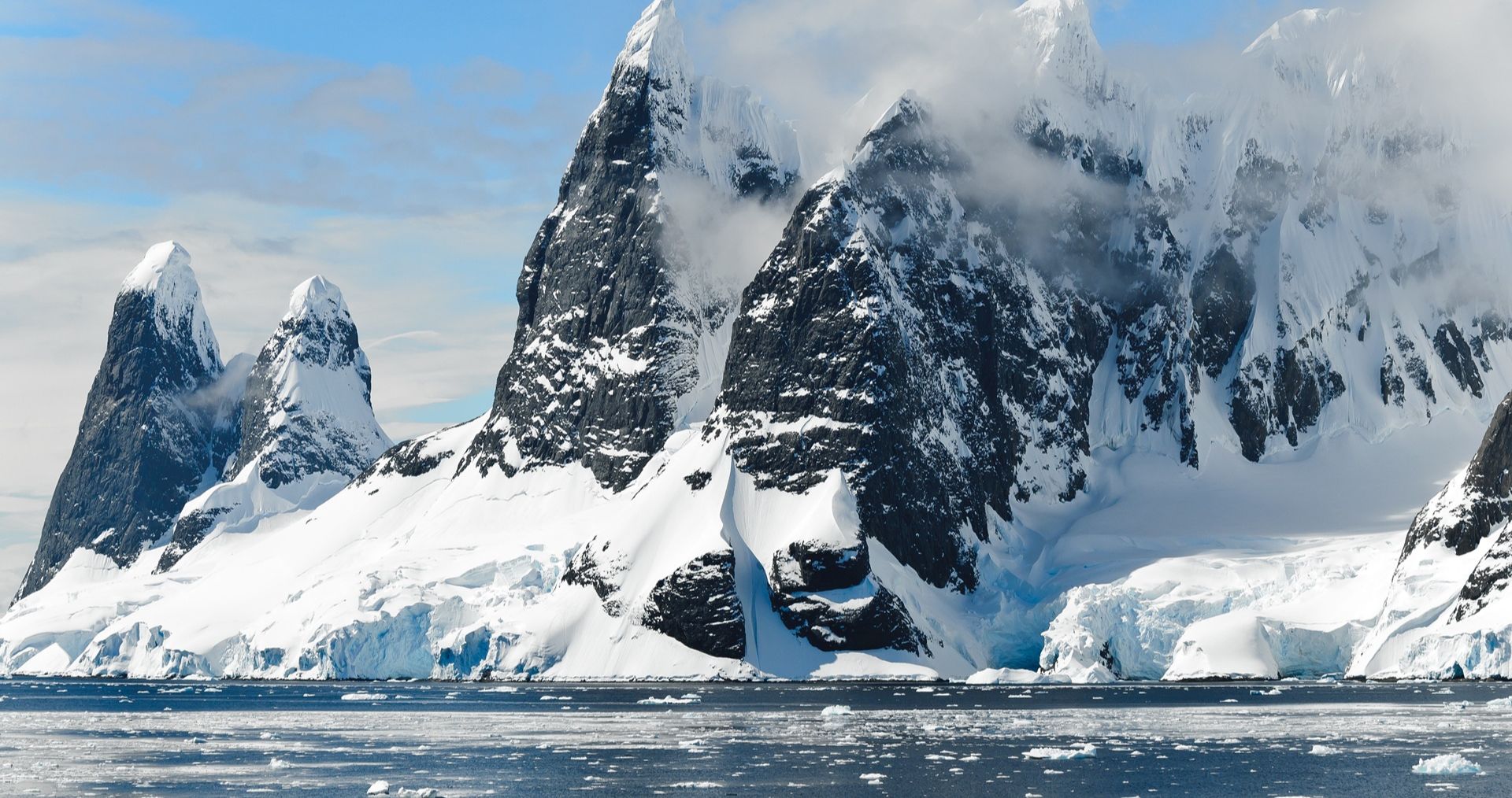 Snow-covered peaks rising above the water in Antarctica