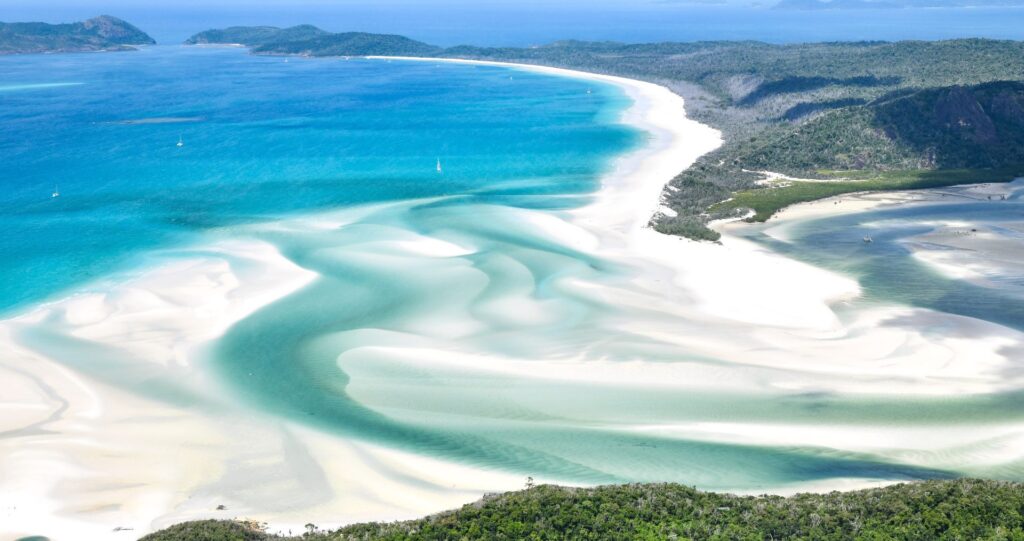 White sand swirling through turquoise water in the Whitsundays