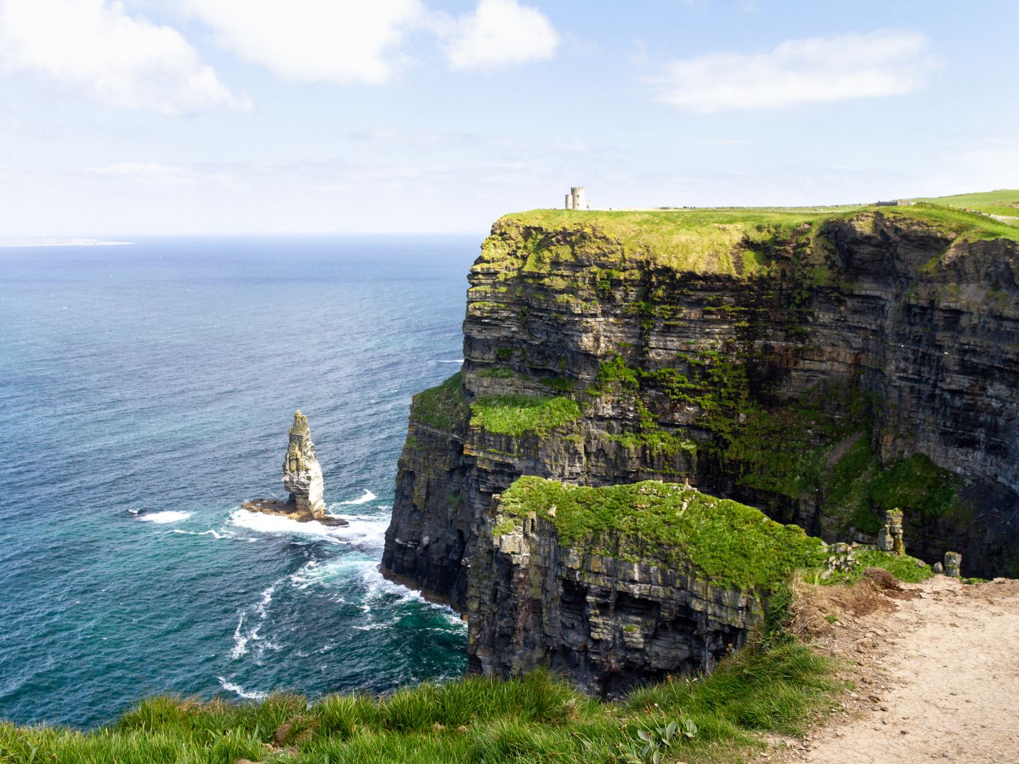 The Cliffs of Moher and a sea stack above the Atlantic Ocean on a sunny day