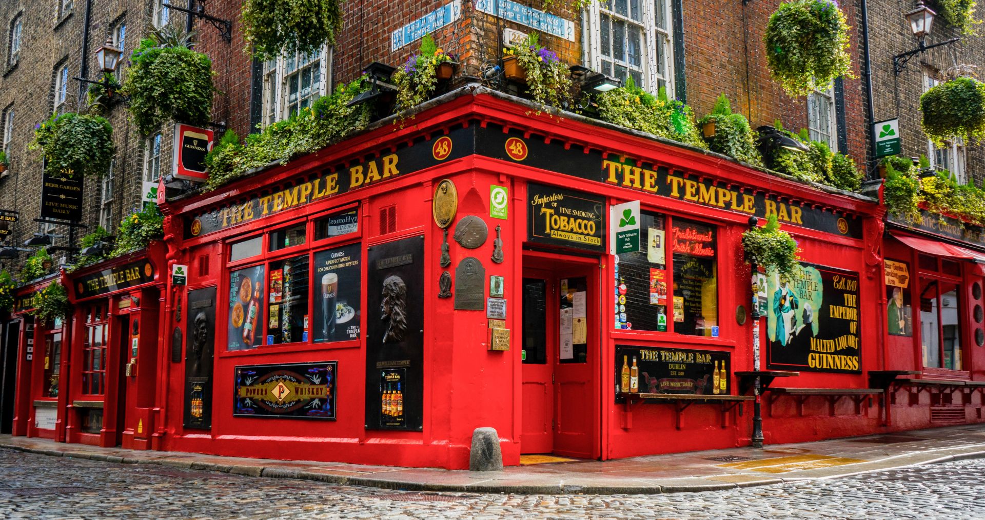 The red facade of the famous Temple Bar pub in Dublin decorated with flowers