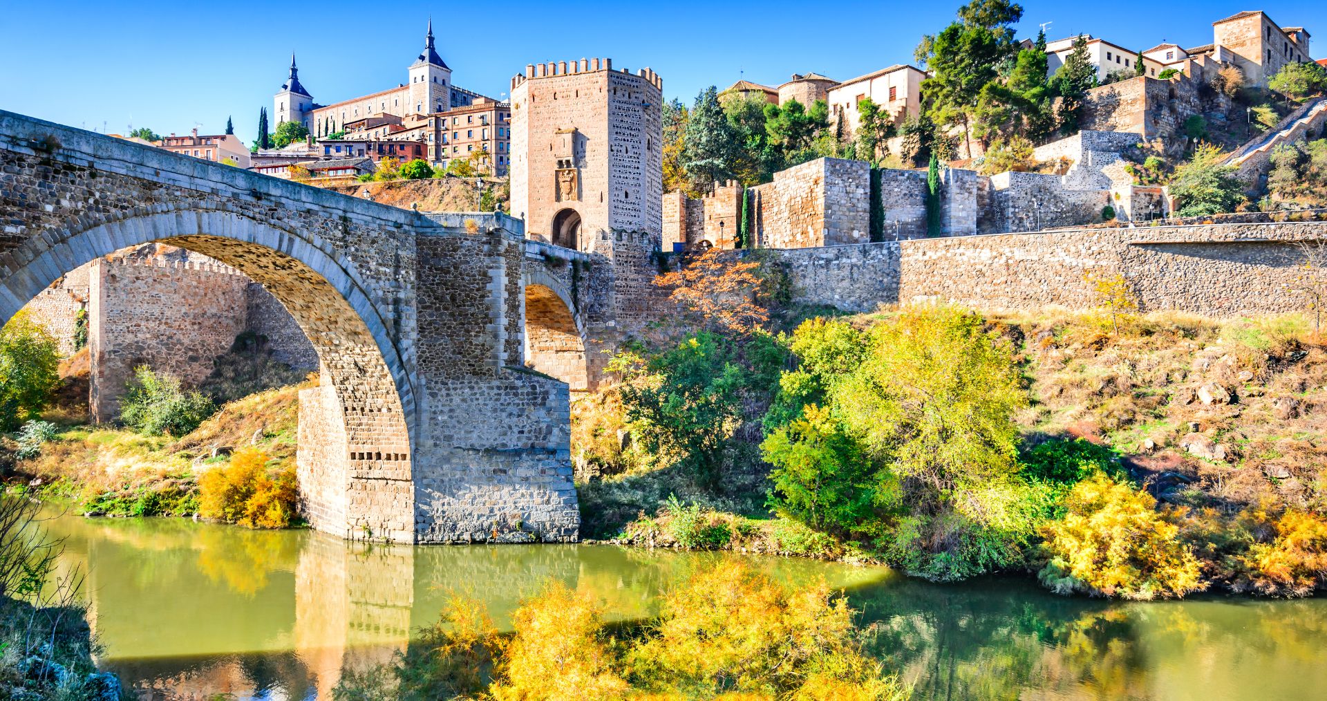 A medieval stone bridge over the Tagus River below the walls of Toledo