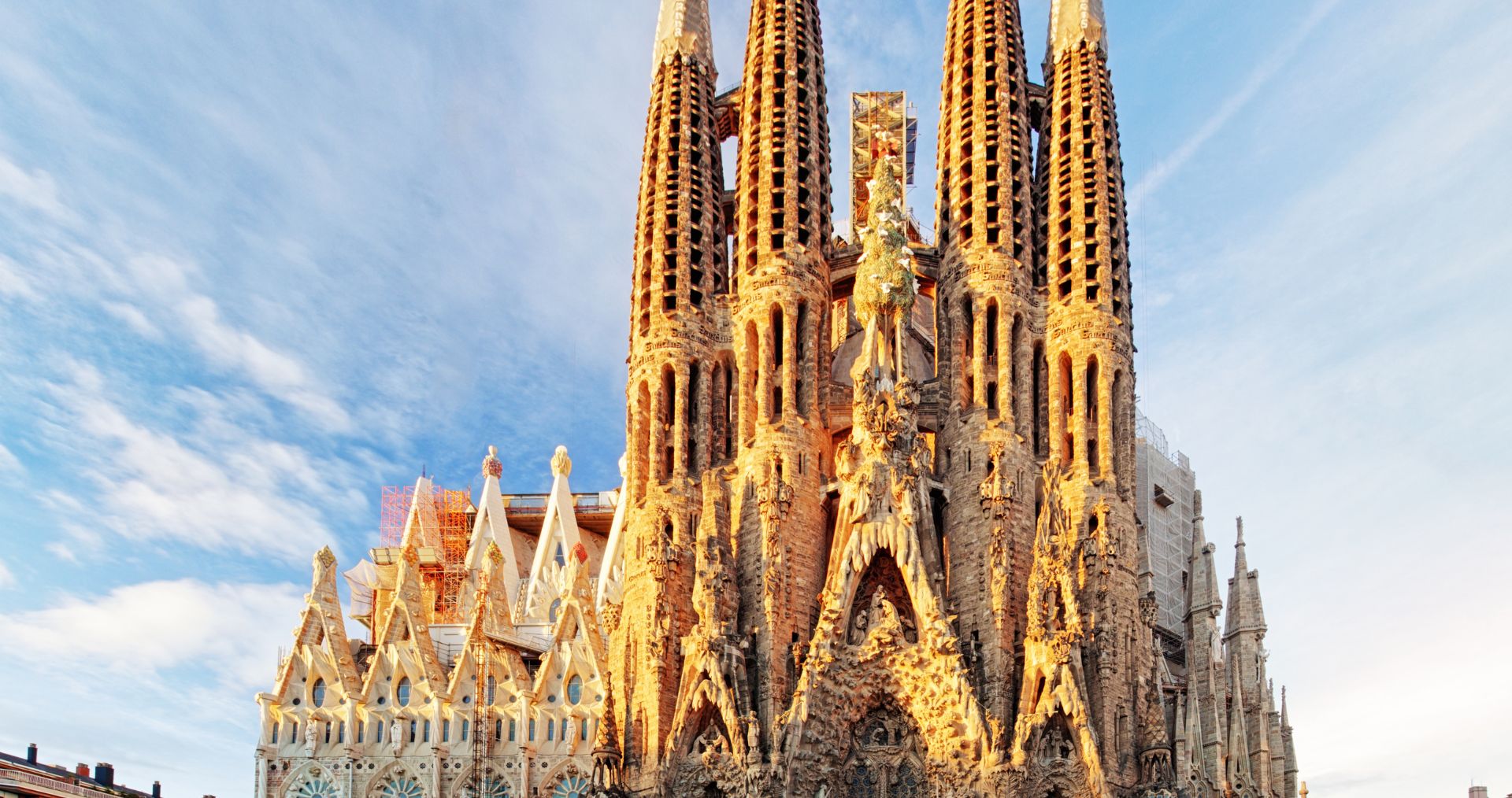 The ornate stone spires of the Sagrada Família against a blue sky