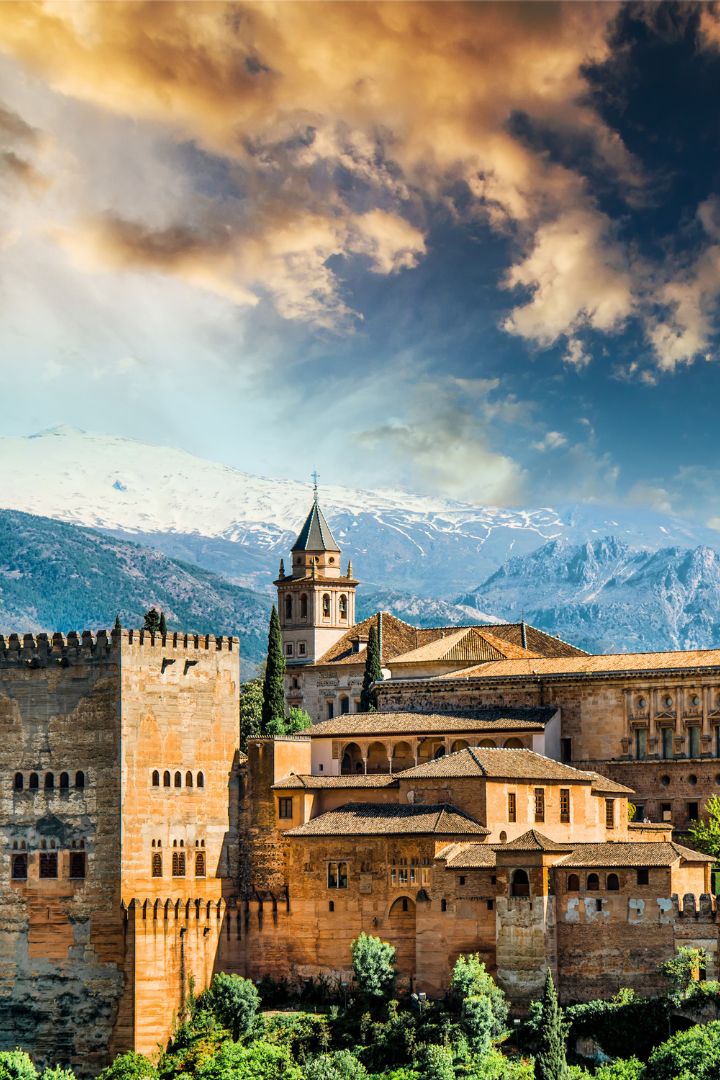 The Alhambra fortress on its hill above Granada with snowy mountains behind
