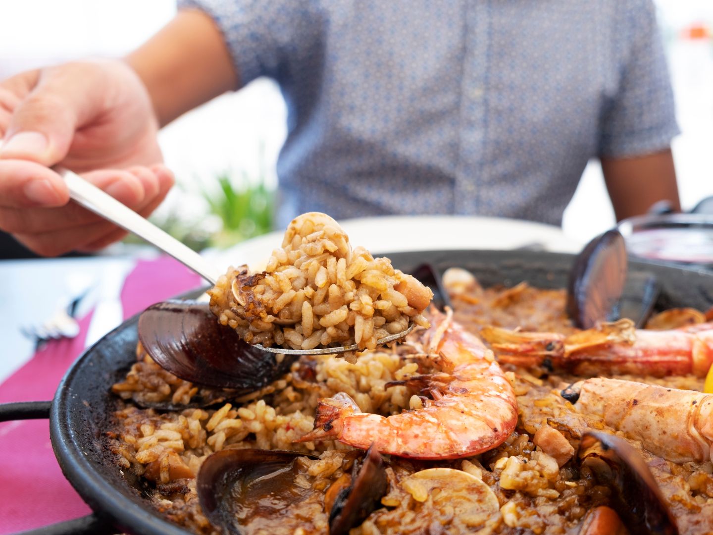 A traditional seafood paella being served at the table