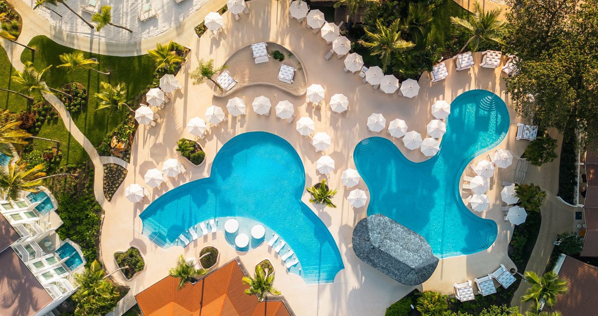 Aerial view of a private villa with a curving pool on a Caribbean hillside