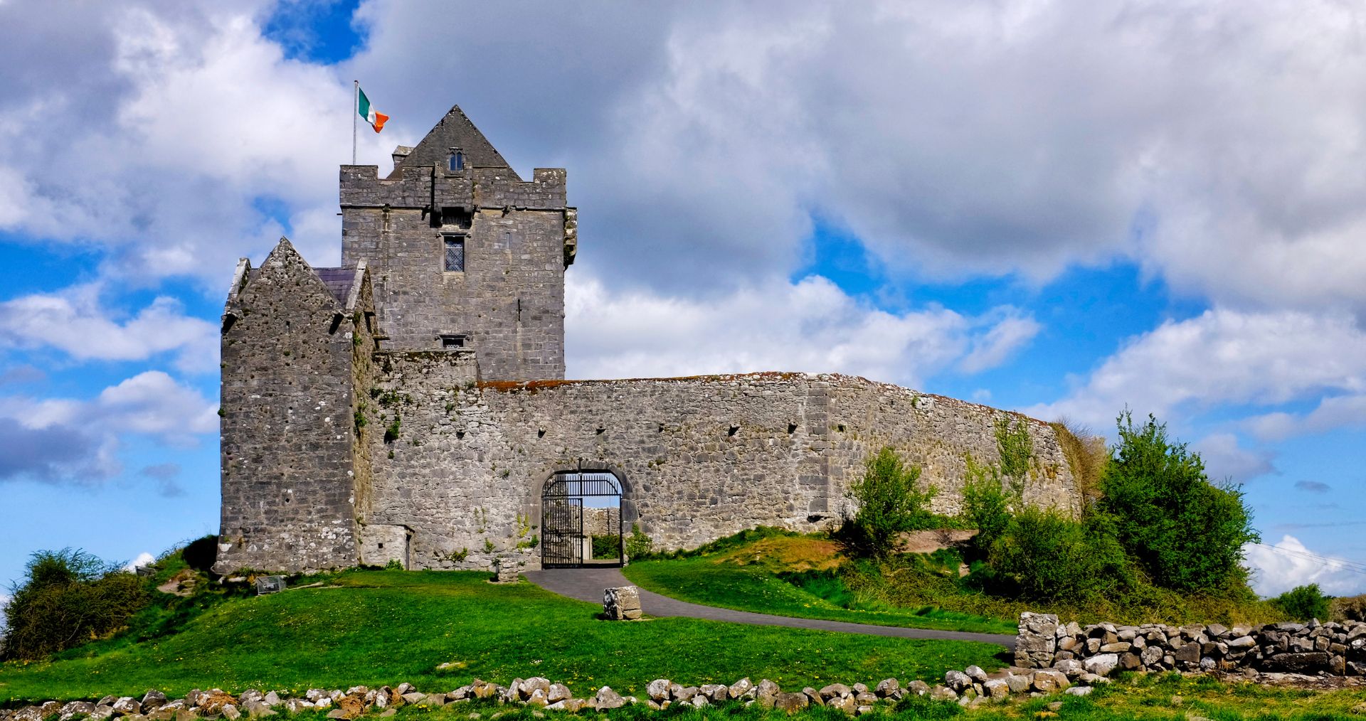 Dunguaire Castle beside Galway Bay under a blue sky