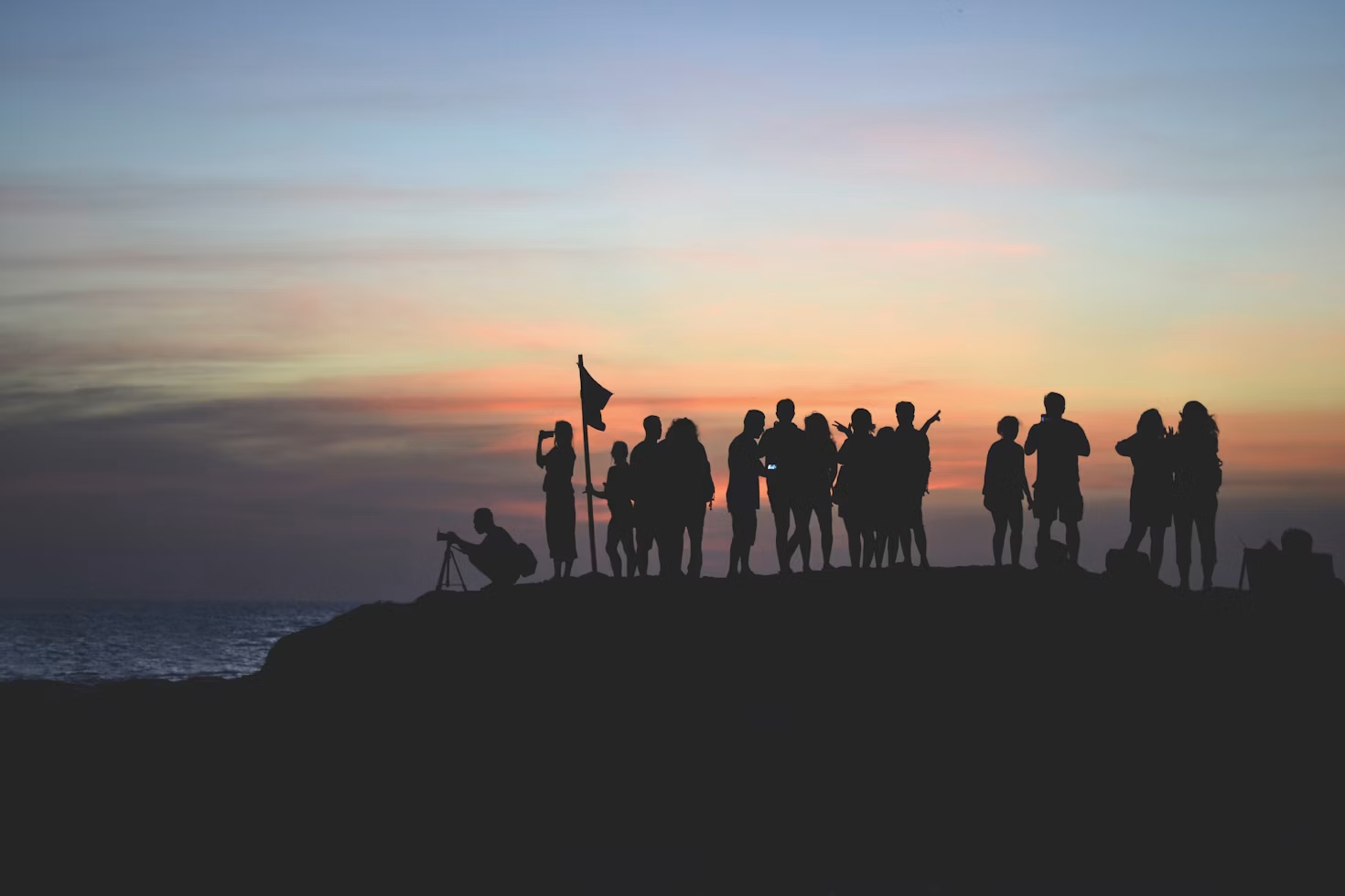 A team of colleagues silhouetted together at sunset