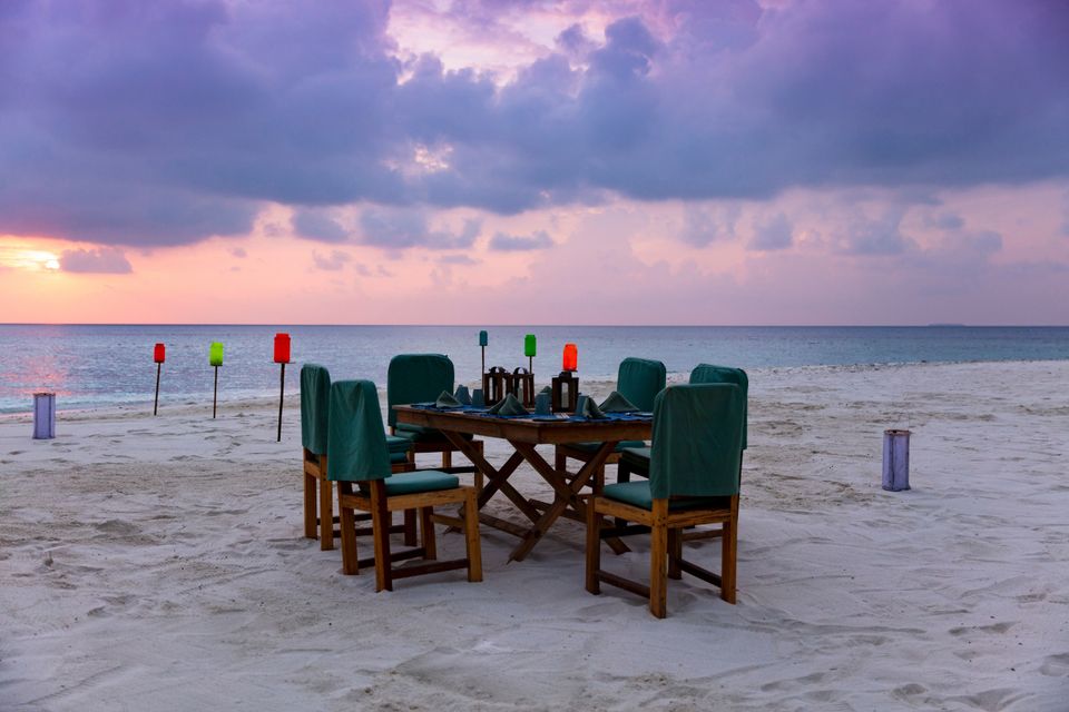 Private beach dinner table set at sunset