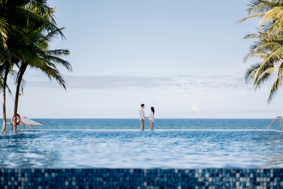 Couple at the edge of an oceanfront infinity pool