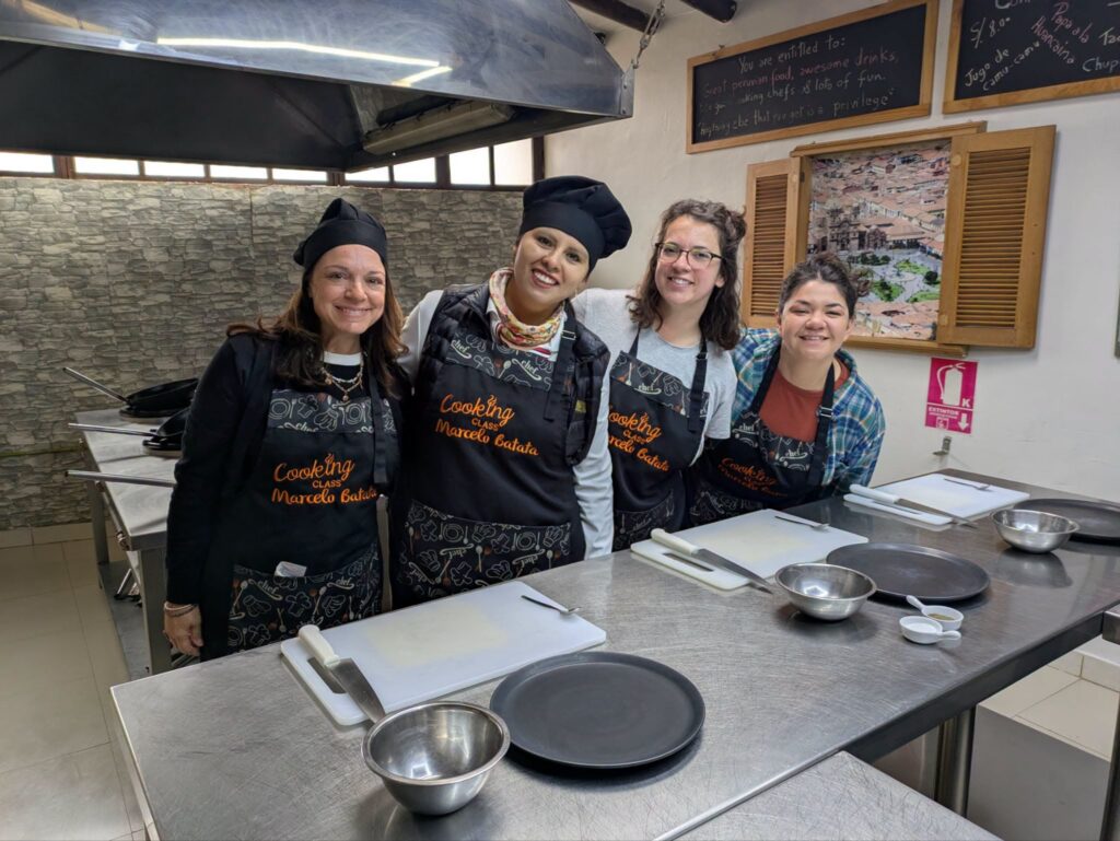 Travel Byrds team in aprons at a Peruvian cooking class