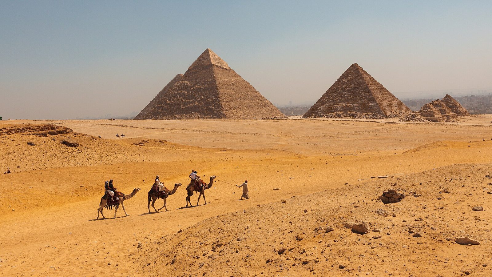 Camel caravan crossing the desert toward the Pyramids of Giza