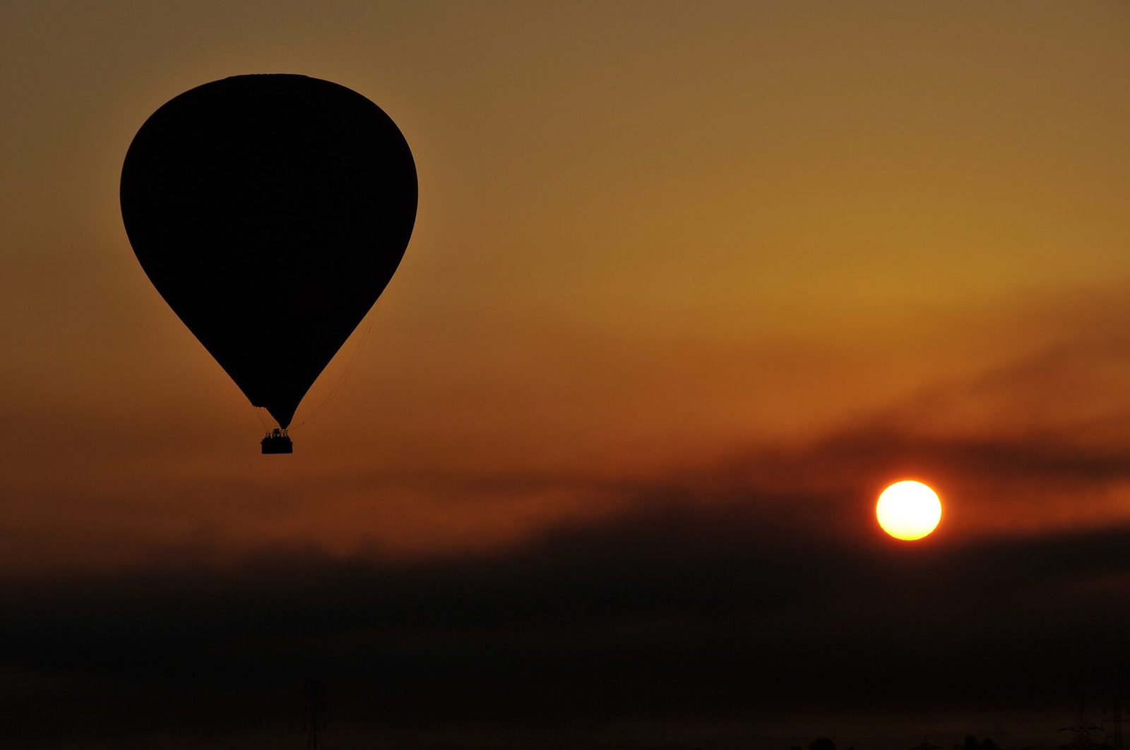 Hot air balloon silhouetted against an Egyptian sunrise