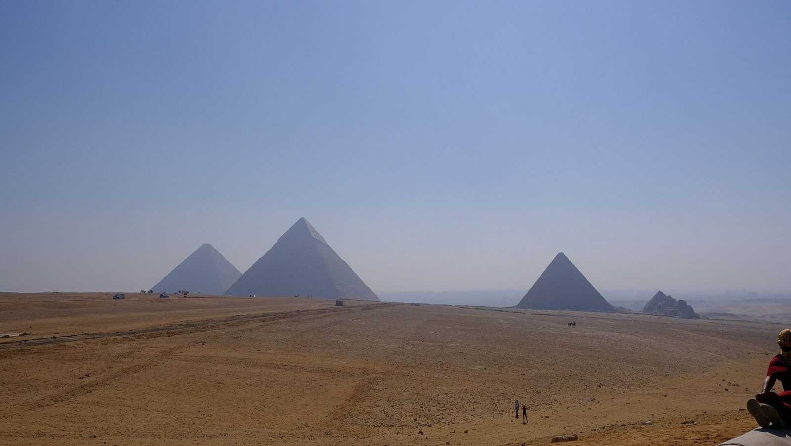 The three Pyramids of Giza seen across the desert plateau
