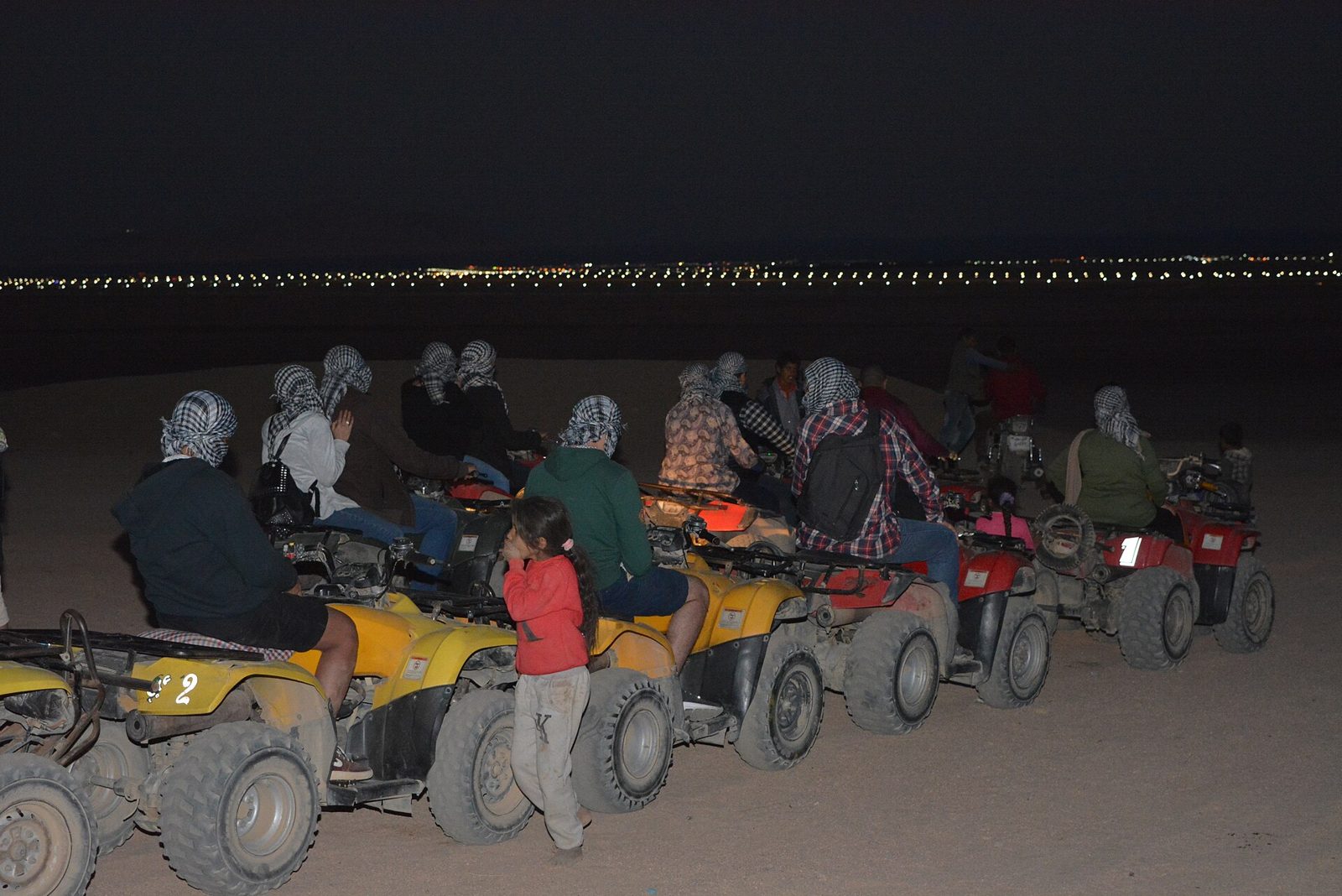 Quad bikes lined up for a desert safari at dusk
